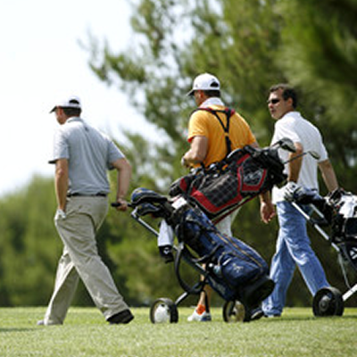 ゴルフバッグを押す人々